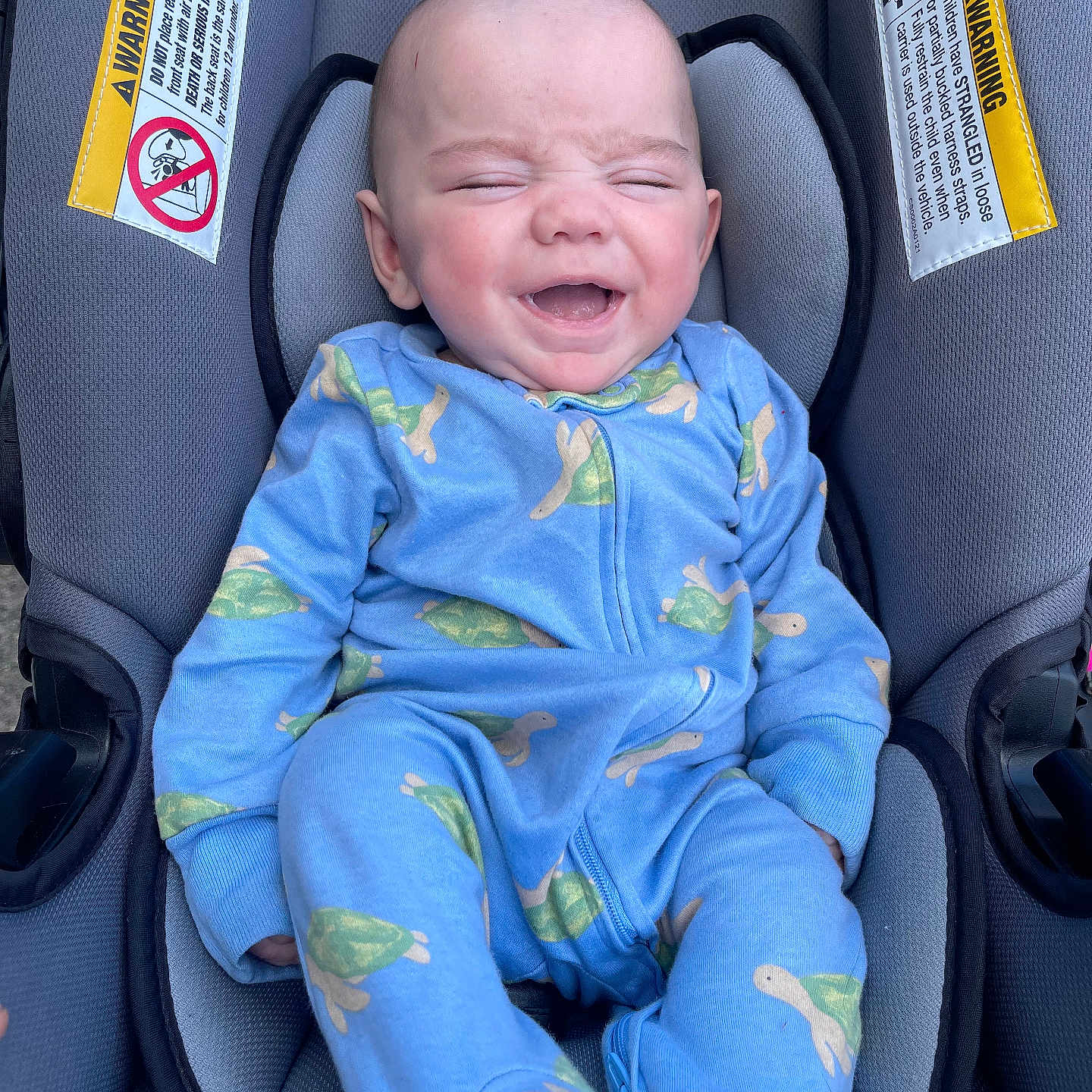 Andrew joined the competition — help win amazing prizes! baby, infant, car_seat, blue_onesie, turtle_print, smiling, happy, child, cute, young, sitting, clothing, fabric, seat, head, face, skin, person, child_seat, comfort