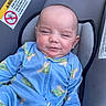 Andrew is registered to the contest to win money with this photo: baby, child, car_seat, blue_onesie, turtle_pattern, smile, face, squinting, infant, clothing, seatbelt_warning, warning_label, safety, portrait, cute, indoor, closeup, person, seat, fabric