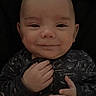 Andrew is registered to the contest to win money with this photo: baby, infant, smile, face, hands, onesie, dark_background, portrait, child, cute, young, person, expression, closeup, skin, head, eyes, newborn, baby_clothing, baby_gesture