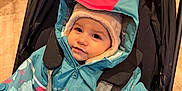 Mayana a rejoint le concours — aidez-le/la à gagner de superbes lots ! child, toddler, stroller, winter_jacket, hat, indoor, baby, seatbelt, cute, warm_clothing, face, baby_carrier, curious, colorful_clothing, infant, sitting, padded_jacket, young_child, smiling, portrait