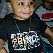 Prince joined the competition — help win amazing prizes! toddler, child, smile, gold_chain, black_shirt, prince_text, diaper, indoor, person, baby, happy, cute, sitting, patterned_blanket, portrait, two_children, dark_hair, casual_clothing, hand, family