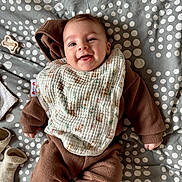 Elyo participe au concours pour gagner de l'argent avec cette photo : baby, bib, blanket, brown_clothing, child, cute, fabric, face, foot, hand, happy, head, infant, lying_down, pacifier, polka_dots, portrait, smiling, sock, soft_toys