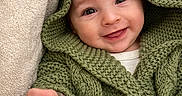Elyo participe au concours pour gagner de l'argent avec cette photo : baby, blanket, button, child, closeup, cozy, cute, face, green_sweater, hand, happy, hoodie, indoors, infant, knitwear, person, portrait, smiling, soft, warm