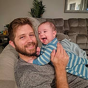 Logan is registered to the contest to win money with this photo: architecture, baby, beard, blanket, building, couch, cushion, face, furniture, happy, head, homedecor, indoors, livingroom, newborn, people, person, photography, portrait, room