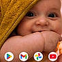 baby, infant, close_up, face, eyes, smile, chubby_cheeks, hand, hood, towel, mustard_yellow, skin, portrait, mobile_screenshot, home_screen, app_icons, play_store_icon, gmail_icon, photos_icon, youtube_icon