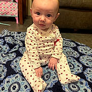 Demi joined the competition — help win amazing prizes! baby, infant, sitting, onesie, heart_pattern, blue_rug, blanket, living_room, sofa, toy_bin, portrait, hands, face, eyes, floor, cozy, indoor, cute, child, carpet