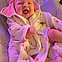 baby, infant, smiling, laughing, robe, carrot_pattern, cushion, seat, cozy, soft_lighting, indoors, child, happy, cute, face, skin, expression, clothing, blanket, comfort