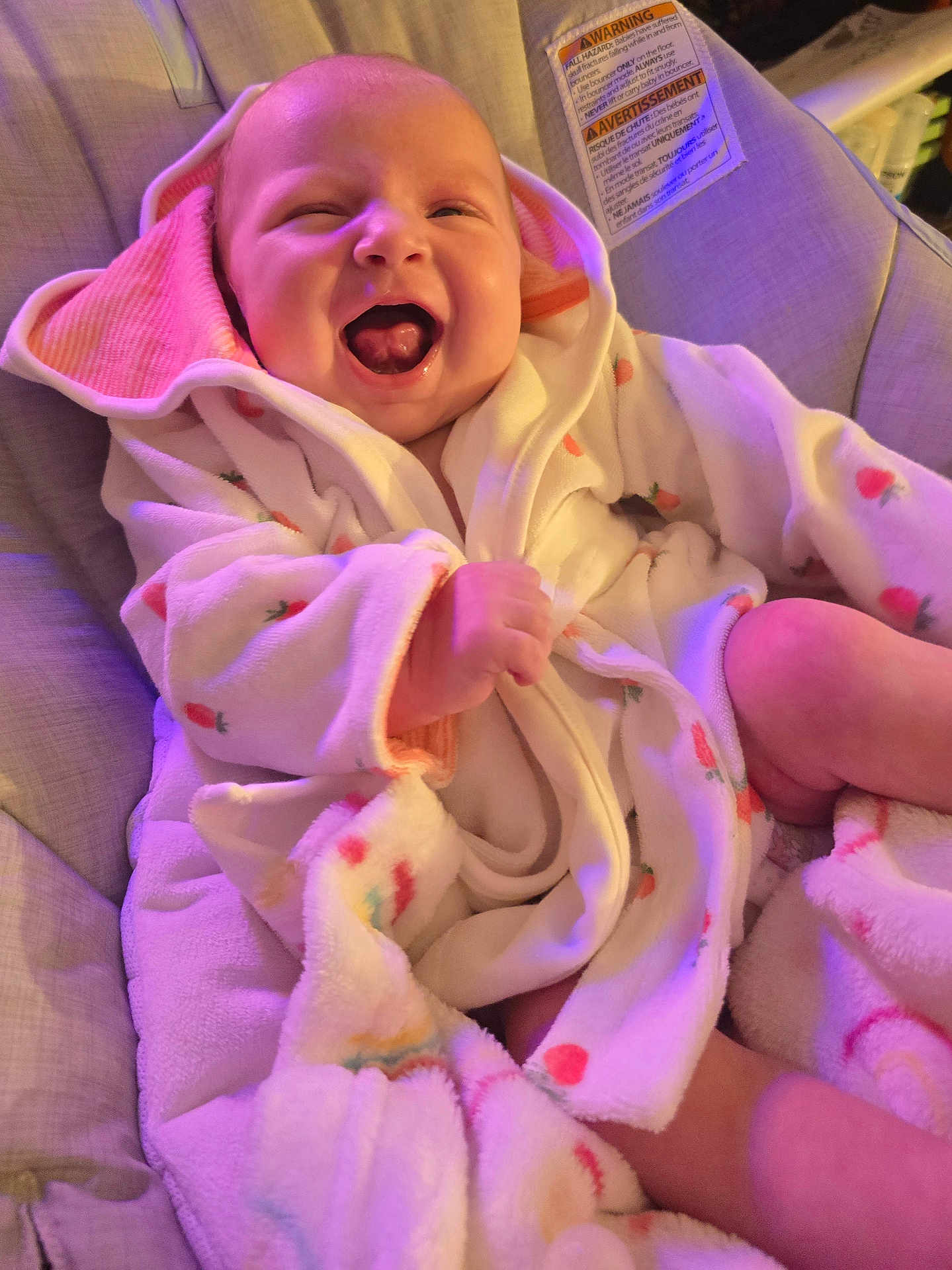 Lily joined the competition — help win amazing prizes! baby, infant, smiling, laughing, robe, carrot_pattern, cushion, seat, cozy, soft_lighting, indoors, child, happy, cute, face, skin, expression, clothing, blanket, comfort