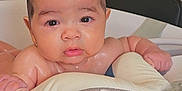 Alan is registered to the contest to win money with this photo: baby, infant, bath, bathroom, water, wet_hair, face, skin, child, cute, sitting, seat, plastic, holding, expression, indoors, young, portrait, looking, curious