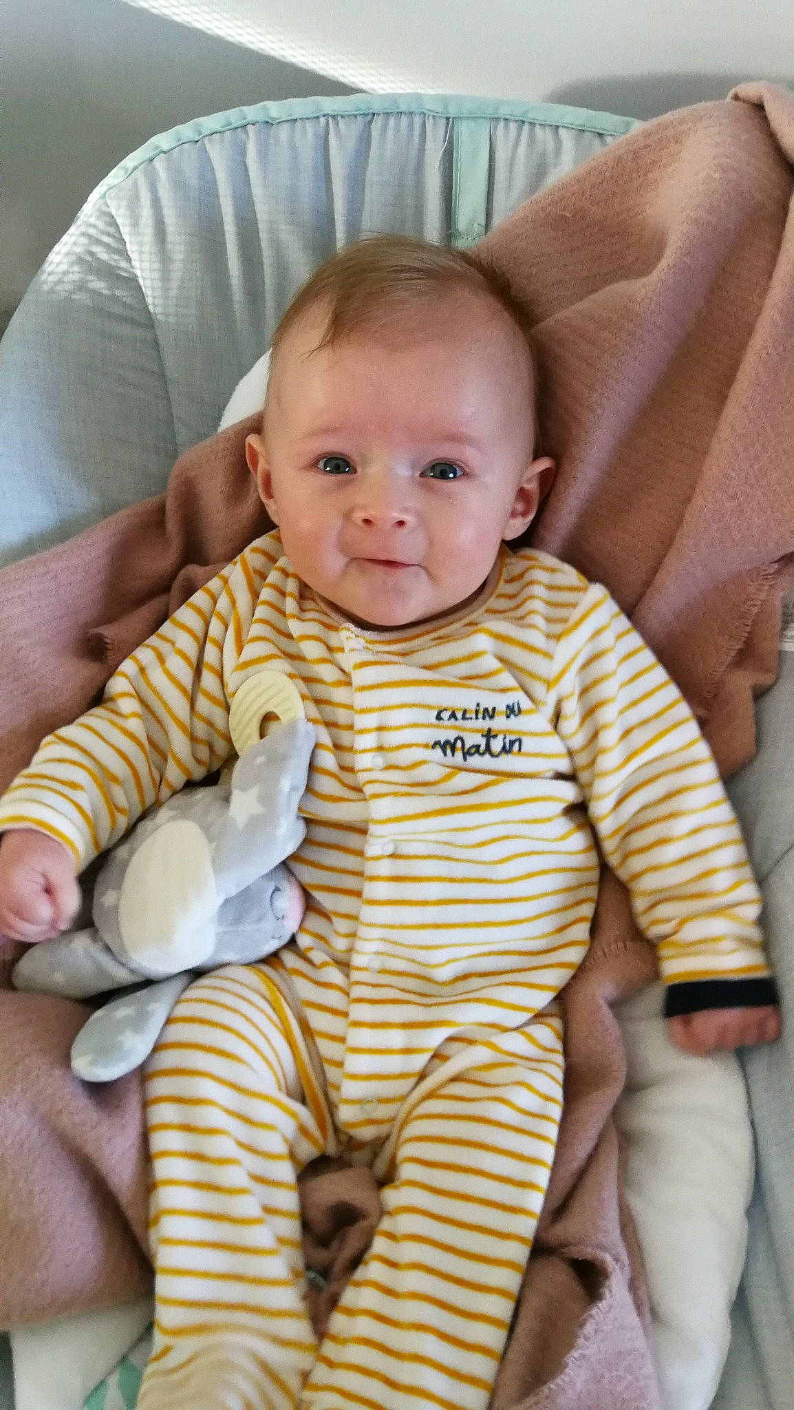 Léo participe au concours pour gagner de l'argent avec cette photo : abdomen, baby, baby_products, baby_toddler_clothing, cheek, chest, child, comfort, face, iris, linens, person, product, room, sitting, skin, sleeve, smile, textile, thumb