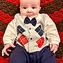 baby, infant, child, bow_tie, outfit, clothing, crocheted_blanket, red, brown, face, hands, eyes, cute, portrait, sitting, fabric, pattern, indoor, young, person