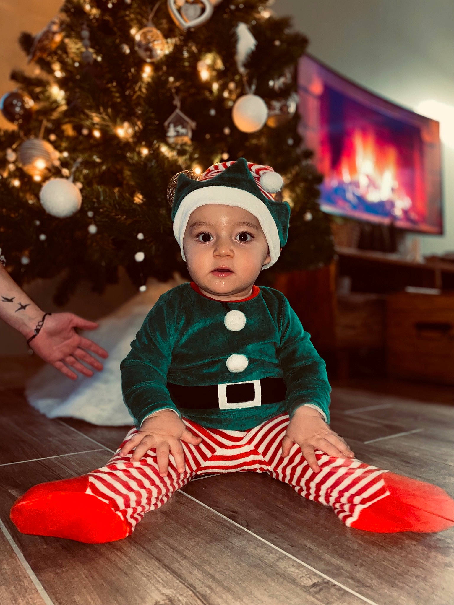 Alessio a rejoint le concours — aidez-le/la à gagner de superbes lots ! baby, baby_toddler_clothing, christmas, christmas_decoration, christmas_eve, christmas_ornament, christmas_tree, event, flooring, fun, happy, headwear, holiday, holiday_ornament, ornament, person, sitting, sleeve, toddler, tree