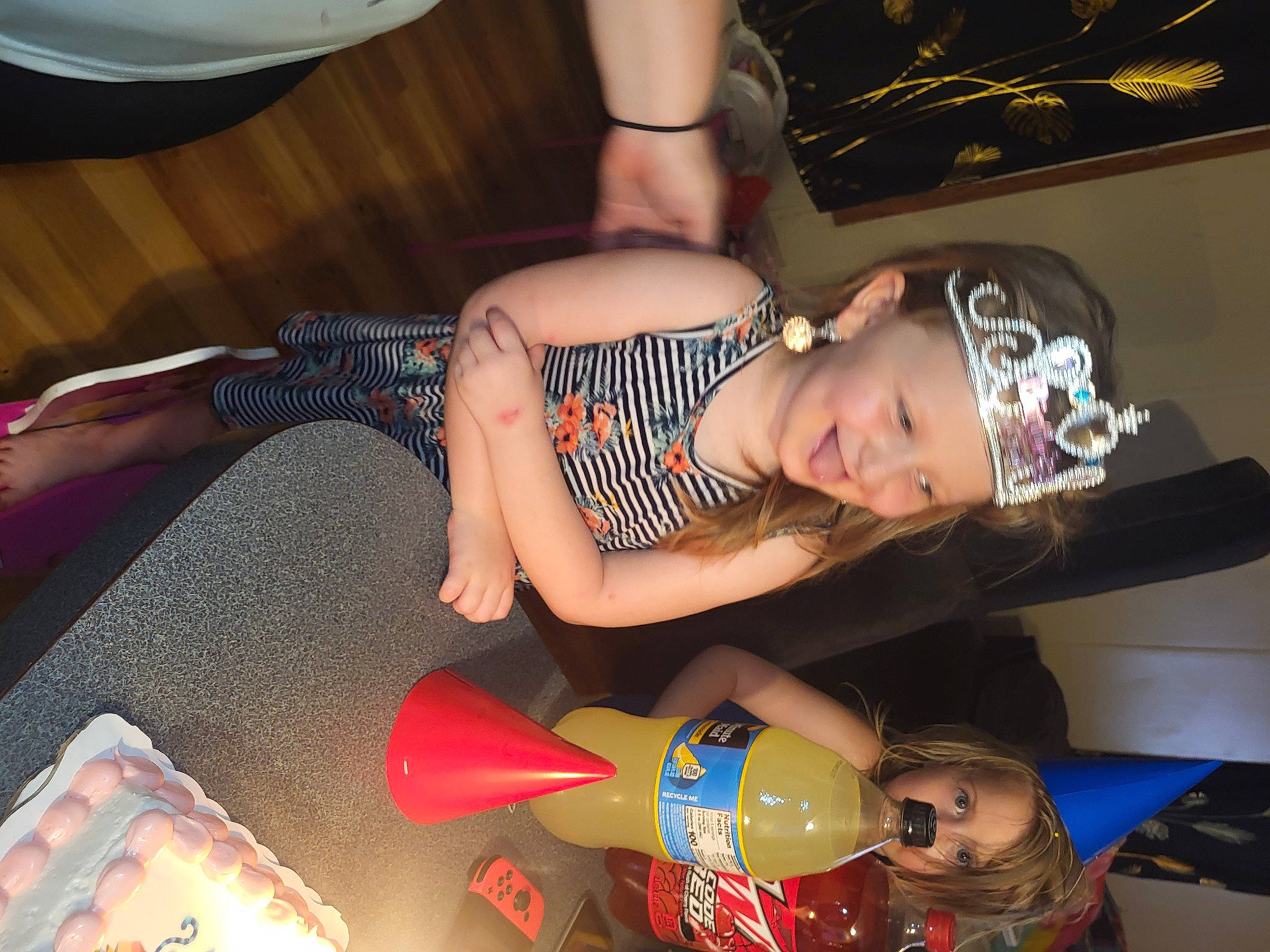 Liliana joined the competition — help win amazing prizes! abdomen, arm, black_hair, chest, child, elbow, event, flesh, fun, headwear, human_leg, joy, knee, lap, mouth, nail, party, person, shorts, sitting