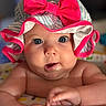baby, child, face, hat, pink_bow, blue_eyes, toy, hand, skin, curious, closeup, striped_hat, infant, play, expression, colorful, indoors, cute, portrait, chubby_cheeks