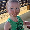 Kayson is registered to the contest to win money with this photo: toddler, child, face, chocolate, smile, green_tank_top, outdoor, bench, curious, messy, cute, portrait, daylight, person, clothing, summer, fun, expression, casual, young_child