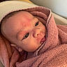 Kayson is registered to the contest to win money with this photo: baby, infant, face, pink_towel, wrapped, skin, head, expression, tongue, closeup, redness, indoors, soft_texture, child, newborn, portrait, cute, young, person, warm_light