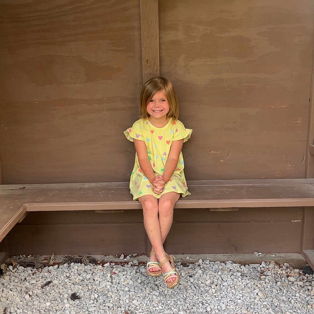 Malayia joined the competition — help win amazing prizes! bench, casual, child, cute, daylight, feet, girl, gravel, happy, nature, outdoor, portrait, relaxed, sandals, sitting, smiling, tree, wood, yellow_dress, young