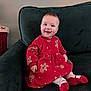 baby, child, smiling, red_dress, gingerbread_men, sitting, couch, green_couch, indoors, happy, cute, holiday_theme, festive, sock, toddler, face, person, portrait, warm, cozy