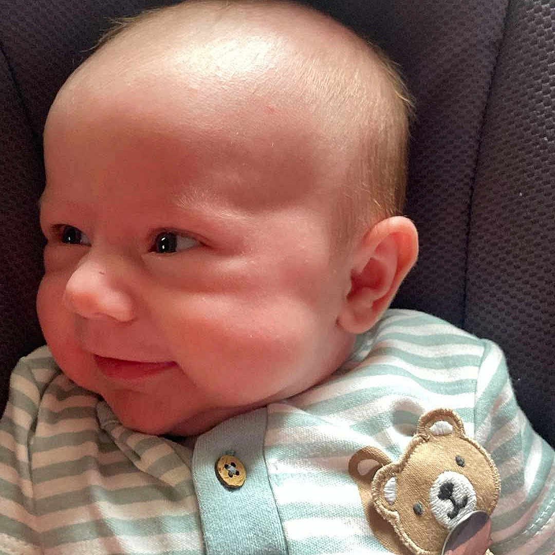 Killian is registered to the contest to win money with this photo: accessories, baby, clothing, cushion, earring, face, furniture, happy, head, homedecor, jewelry, newborn, pants, person, photography, portrait, shirt, sleeping, smile, t_shirt