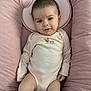 Jupiter is registered to the contest to win money with this photo: baby, infant, child, pink_cushion, onesie, cute, face, blue_eyes, plush, soft, comfortable, clothing, portrait, indoors, sitting, smile, skin, head, hand, young