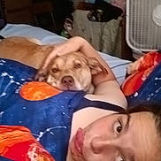 Ell is registered to the contest to win money with this photo: person, dog, bed, blanket, cuddle, face, indoor, fan, furniture, relaxation, comfort, sleepwear, expression, resting, home, casual, portrait, animal, companionship, cozy