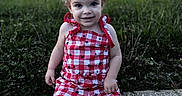 Atleigh is registered to the contest to win money with this photo: bokeh, checkered_clothing, child, city_lights, curb, evening, girl, grass, happy, outdoor, photograph, pink_shoes, playful, portrait, red_outfit, sidewalk, sitting, smiling, star_pattern, toddler