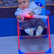 Munraj is registered to the contest to win money with this photo: baby, child, chair, light_stick, indoor, floor, socks, pants, shirt, face, hands, toy, fireplace, blue, red, comfort, seated, expression, person, home