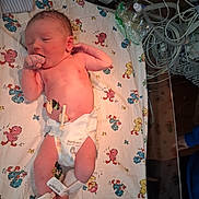 Colton joined the competition — help win amazing prizes! newborn, baby, infant, hospital, medical_equipment, hospital_bed, blanket, diaper, sleeping, yawning, lying_down, portrait, face, umbilical_care, monitoring, tubing, nursery, cartoon_blanket, healthcare, photography