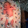 newborn, baby, infant, hospital, medical_equipment, hospital_bed, blanket, diaper, sleeping, yawning, lying_down, portrait, face, umbilical_care, monitoring, tubing, nursery, cartoon_blanket, healthcare, photography
