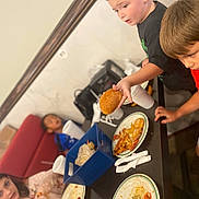 Maverix Ryder joined the competition — help win amazing prizes! child, children, table, food, pizza, donut, plate, drink, cup, napkins, indoor, casual, snack, red_shirt, black_shirt, blue_shirt, sitting, eating, friends, social