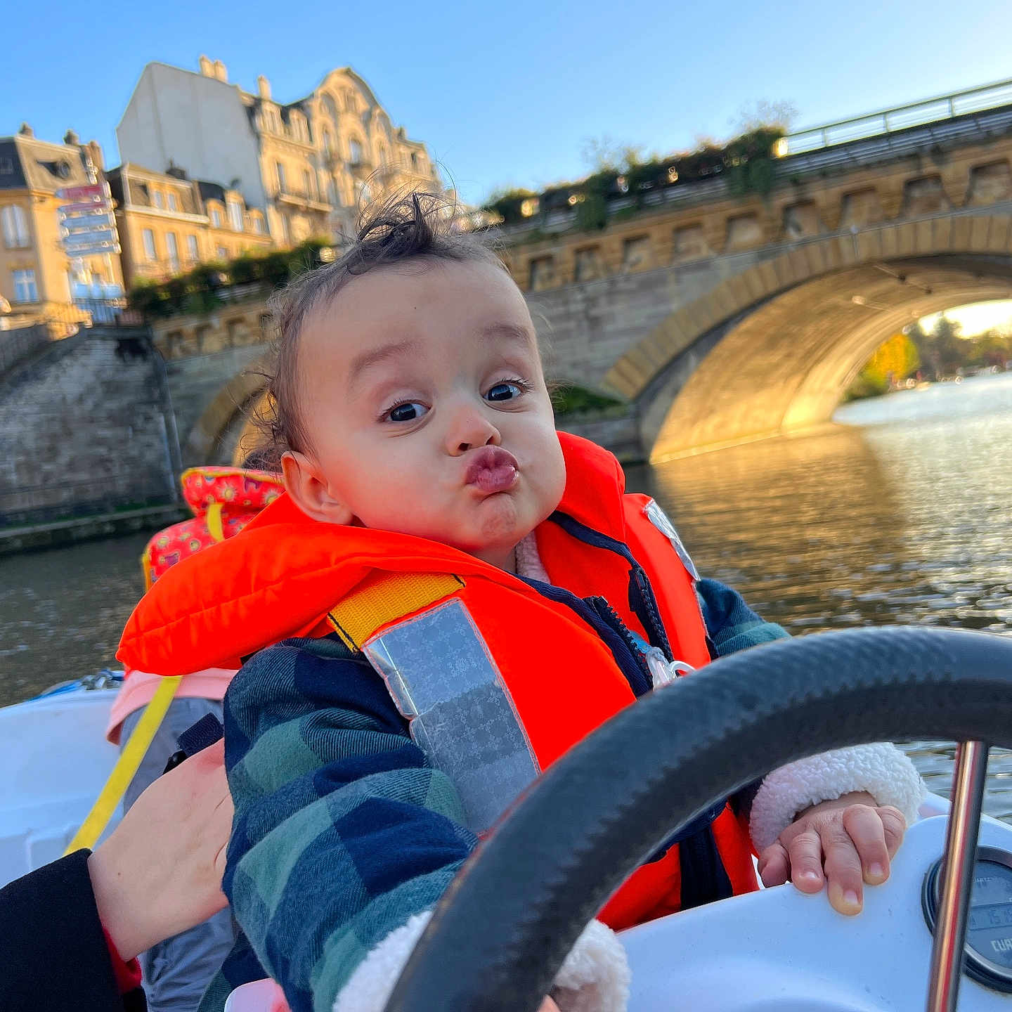 Léo a rejoint le concours — aidez-le/la à gagner de superbes lots ! adult, baby, bridge, clothing, coat, face, head, jacket, lifejacket, male, man, neighborhood, outdoors, person, photography, portrait, transportation, vehicle, vest, water