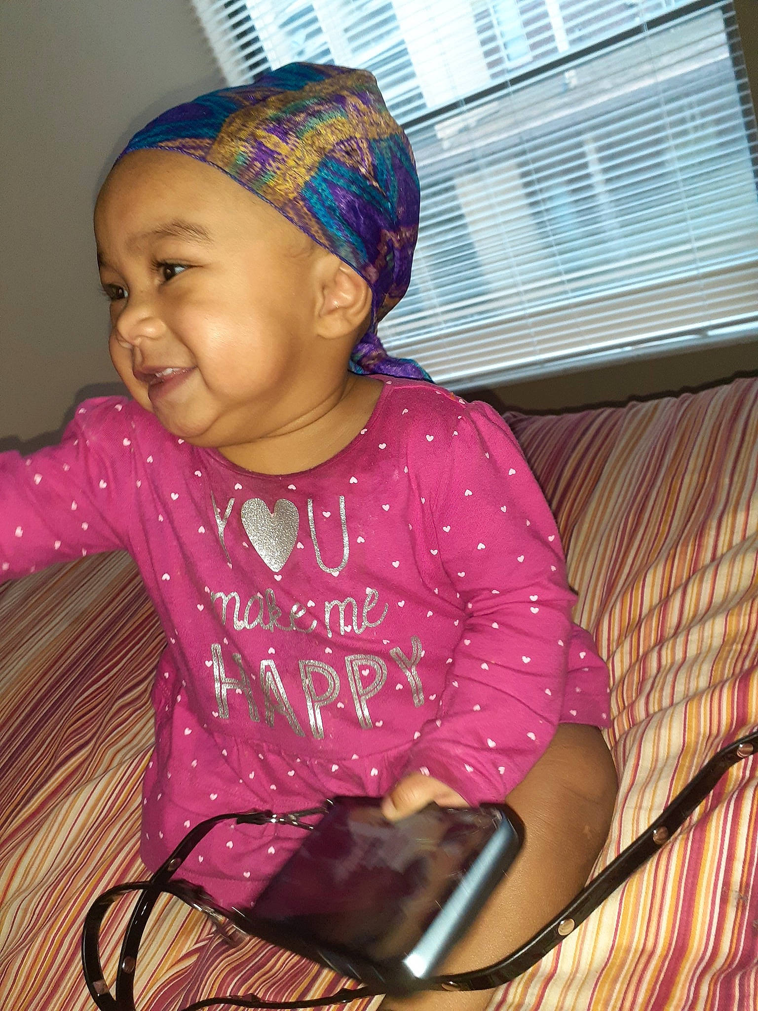 Maliaha is registered to the contest to win money with this photo: adaptation, baby, bonnet, cap, cheek, child, electronic_device, fashion_accessory, hair_accessory, happy, head, headgear, knit_cap, knitting, lip, person, pink, skin, smile, toddler