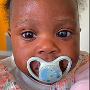 Theresa participe au concours pour gagner de l'argent avec cette photo : baby, pacifier, face, close_up, child, infant, plush_toy, pink, floral_pattern, cute, indoors, portrait, young_child, soft_toy, apparel, expression, skin, eyes, head, clothing