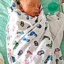 Jensen is registered to the contest to win money with this photo: newborn, baby, sleeping, blanket, swaddled, pacifier, footprint_pattern, infant, soft, bed, cute, peaceful, wrapped, comfort, child, face, head, rest, indoors, person