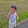 blue_eyes, boy, cap, casual_clothing, child, curious, daylight, grass, green_wrapper, minecraft, outdoor, path, person, shorts, snack, sneakers, summer, toddler, white_tank_top, young_child