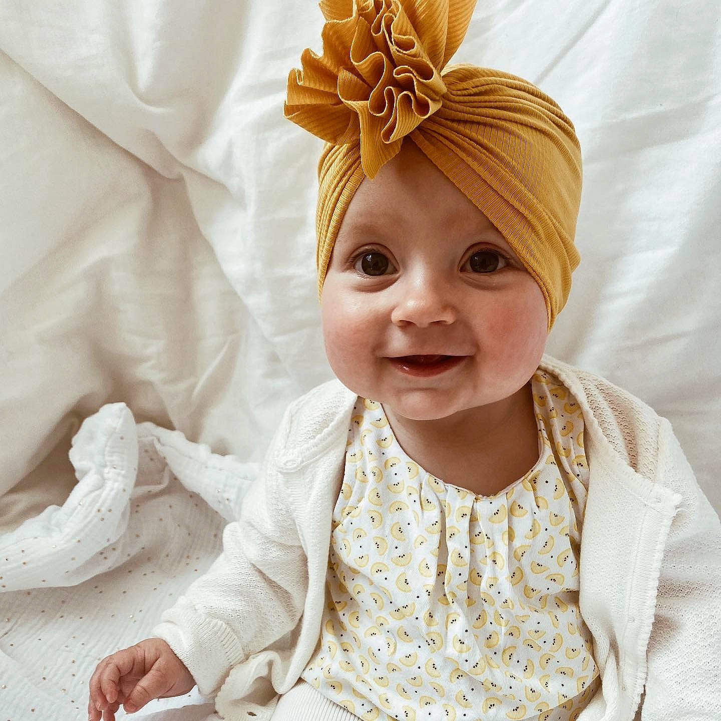 Elya a rejoint le concours — aidez-le/la à gagner de superbes lots ! baby, baby_toddler_clothing, bridal_accessory, child, costume_hat, dress, event, facial_expression, happy, hat, headband, headpiece, jewellery, outerwear, peach, person, skin, sleeve, smile, toddler