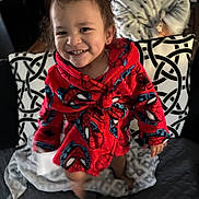 Legend is registered to the contest to win money with this photo: child, toddler, smiling, portrait, spiderman, robe, red_clothing, superhero, blanket, cushion, couch, indoor, home, seated, standing, happy, face, hair, patterned_fabric, photography
