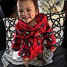 child, toddler, smiling, portrait, spiderman, robe, red_clothing, superhero, blanket, cushion, couch, indoor, home, seated, standing, happy, face, hair, patterned_fabric, photography