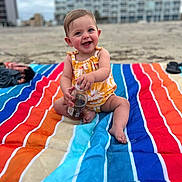 Oaklynn is registered to the contest to win money with this photo: baby, beach, blanket, bottle, child, cute, happy, infant, outdoor, person, playful, portrait, sand, sitting, smiling, striped, summer, sunny, vacation, yellow_clothing