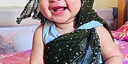 Samriddha joined the competition — help win amazing prizes! baby, child, smiling, scarf, clothing, bed, blanket, fabric, indoors, person, cute, happy, portrait, human, skin, face, hand, sitting, headwear, textile