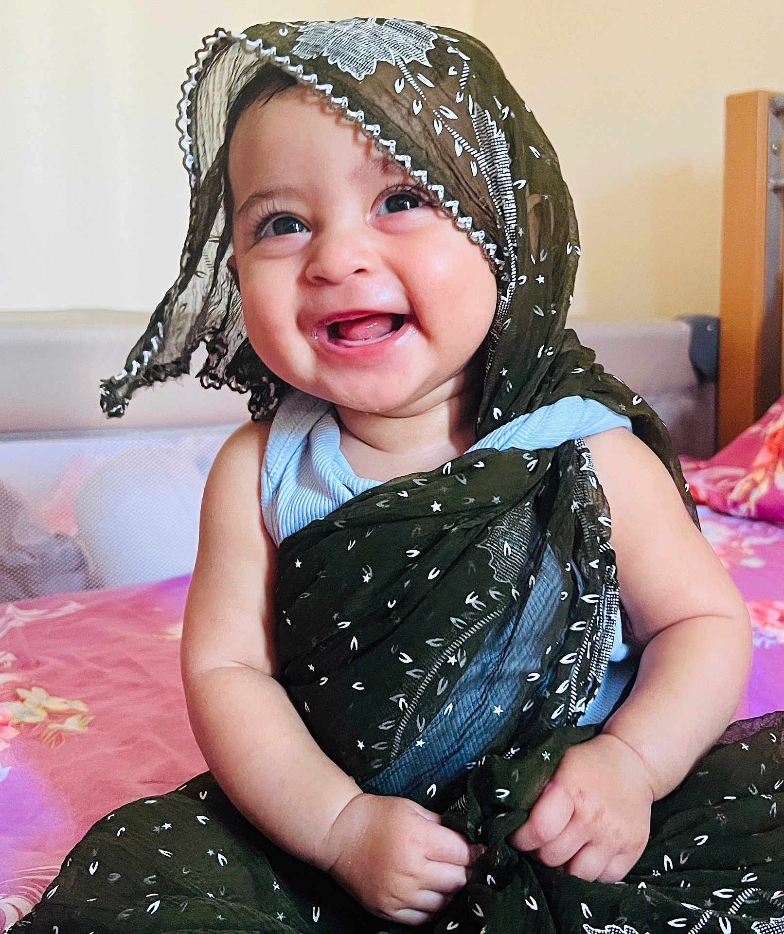 Samriddha joined the competition — help win amazing prizes! baby, child, smiling, scarf, clothing, bed, blanket, fabric, indoors, person, cute, happy, portrait, human, skin, face, hand, sitting, headwear, textile