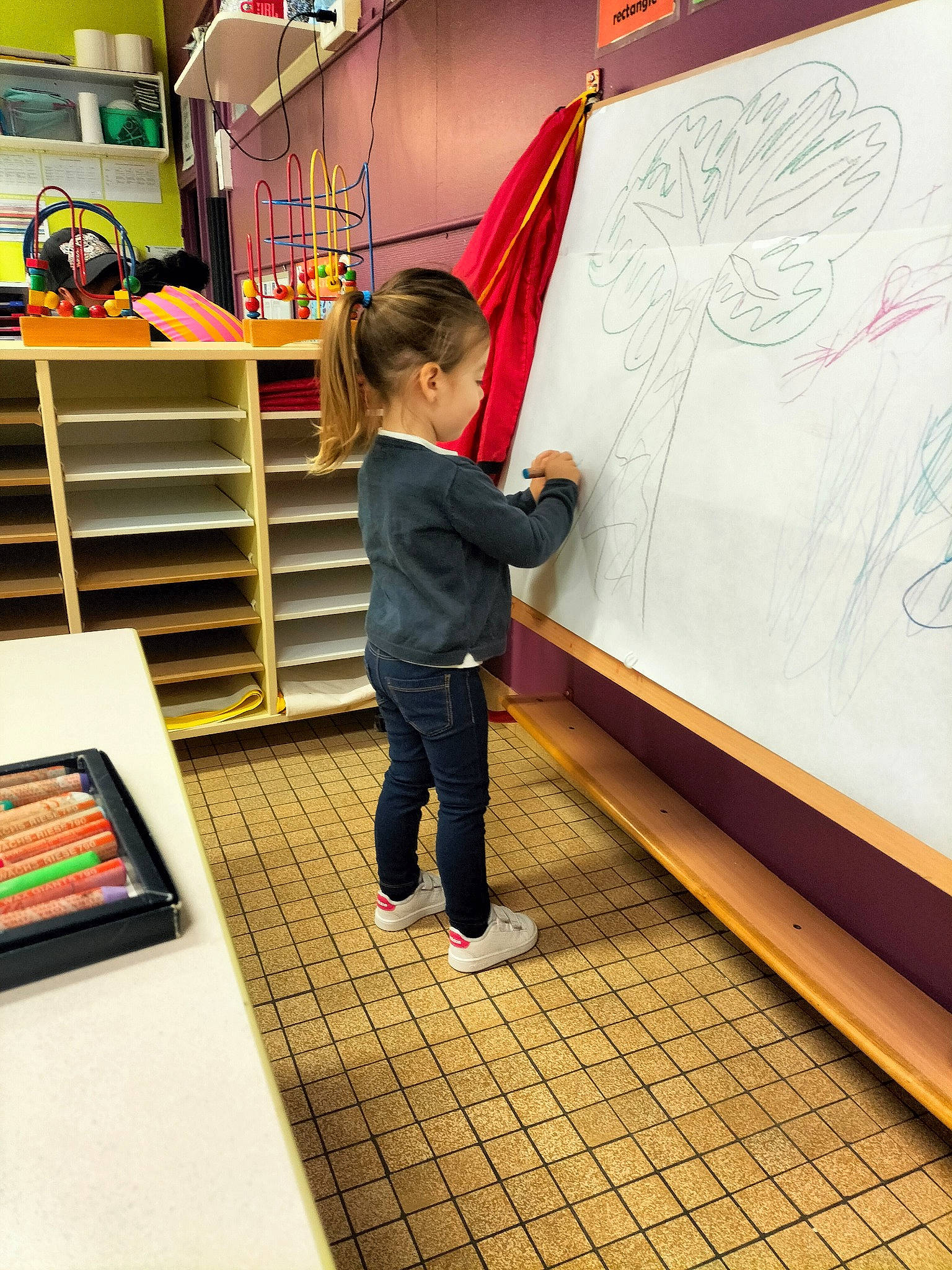 Léana a rejoint le concours — aidez-le/la à gagner de superbes lots ! child, floor, flooring, fun, handwriting, leisure, line, person, play, room, shelf, shelving, snapshot, standing, t_shirt, toddler, transport, visual_arts, whiteboard, writing