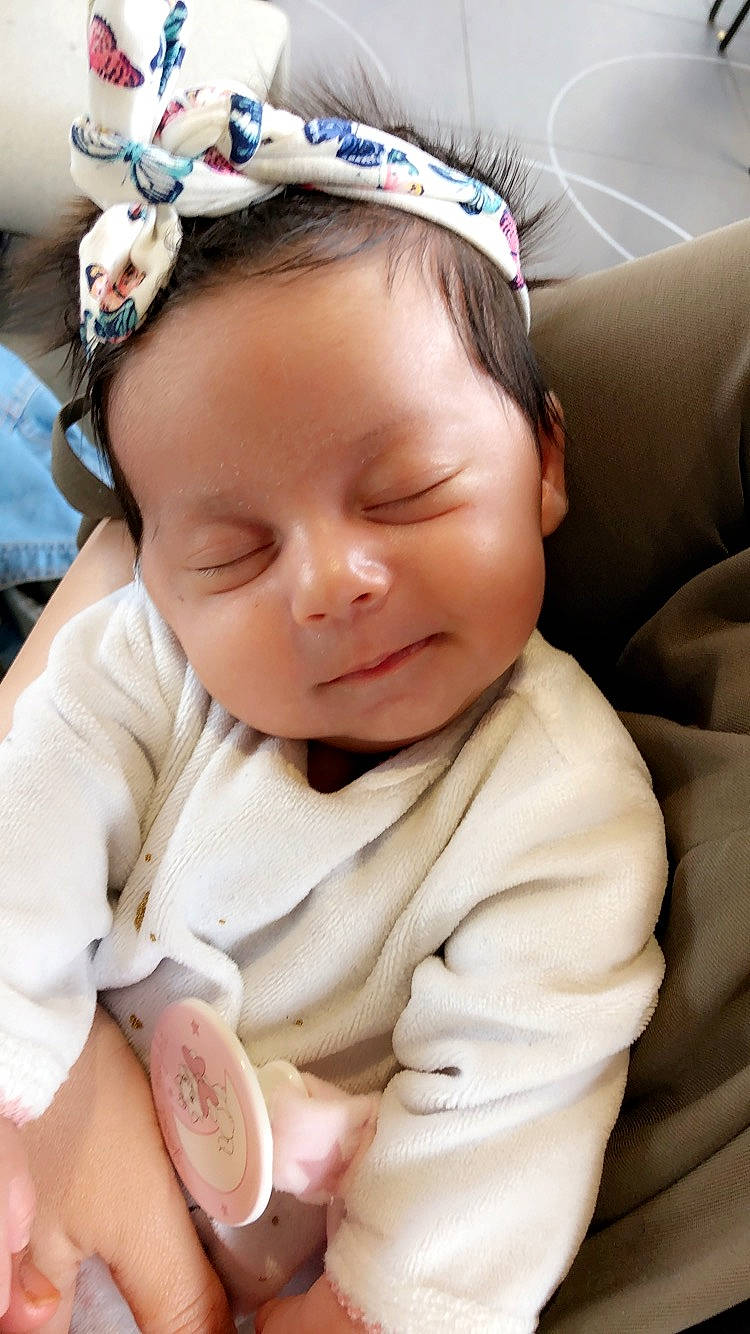 Leyna participe au concours pour gagner de l'argent avec cette photo : baby, baby_toddler_clothing, cheek, child, comfort, ear, eyelash, face, finger, happy, head, headpiece, lip, nose, person, pink, skin, sleeve, smile, toddler