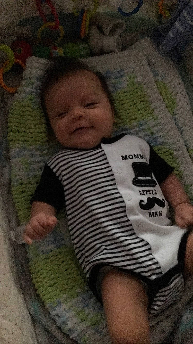 Jasiah is registered to the contest to win money with this photo: arm, baby, baby_carriage, baby_products, baby_toddler_clothing, cheek, child, eye, finger, head, human, leg, mouth, nose, person, play, product, sitting, skin, smile