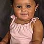 Milah is registered to the contest to win money with this photo: baby, child, girl, bow, pink_outfit, plush_toy, green_toy, couch, smile, cute, indoor, portrait, sitting, happy, closeup, adorable, infant, dark_background, soft_toy, person