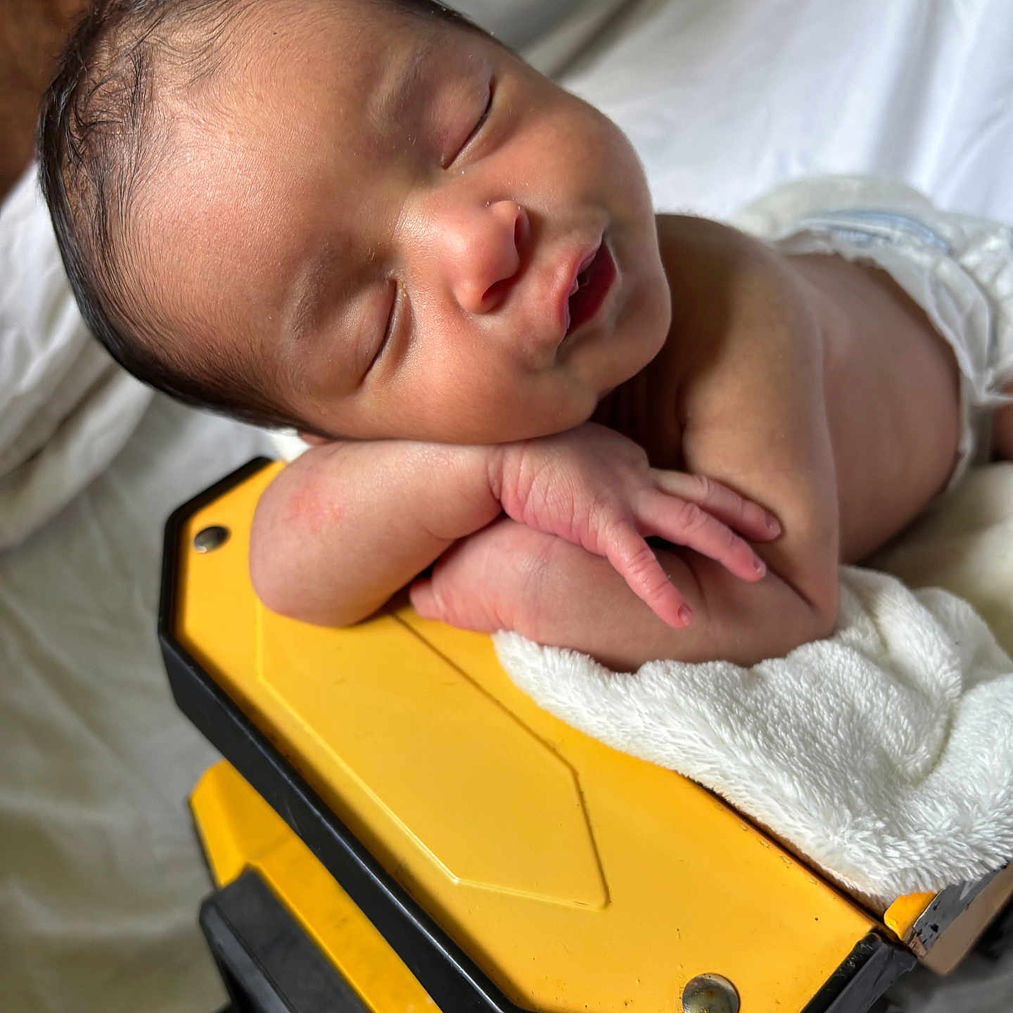 Admire is registered to the contest to win money with this photo: arm, baby, blanket, closeup, cute, face, hand, indoors, infant, newborn, peaceful, portrait, relaxation, resting, skin, sleep, sleeping, soft_light, toddler, yellow_object