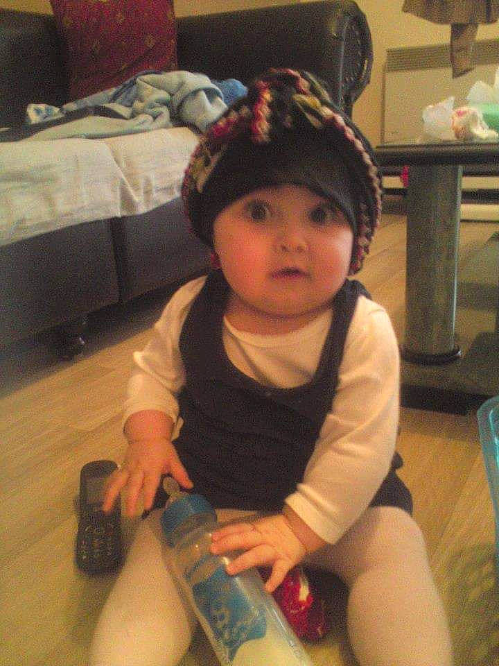 Dalya a rejoint le concours — aidez-le/la à gagner de superbes lots ! baby, baby_toddler_clothing, bottle, cap, cheek, child, comfort, drinkware, eye, flooring, fun, headwear, human_body, human_leg, knee, nail, person, plastic_bottle, skin, thigh