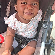 Mai'Lani joined the competition — help win amazing prizes! baby, casual, child, curly_hair, cute, daylight, earrings, floral_top, hands, happy, infant, outdoor, person, portrait, seatbelt, smiling, stroller, summer, sunlight, toddler