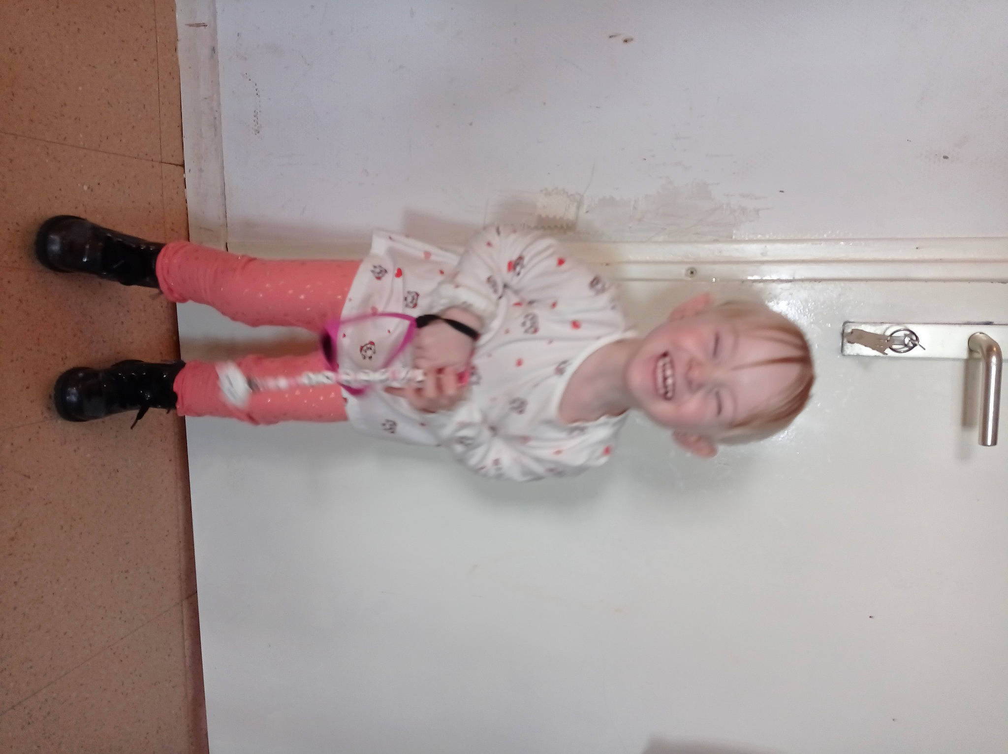 Maëlyne participe au concours pour gagner de l'argent avec cette photo : baby, baby_toddler_clothing, carmine, child, door, door_handle, foot, human_leg, joy, knee, person, pink, room, sandal, sitting, skin, smile, sock, thigh, toddler