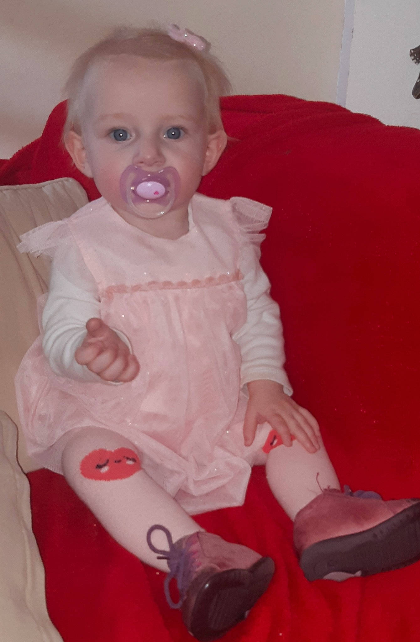 Maëlyne participe au concours pour gagner de l'argent avec cette photo : arm, baby, cheek, child, eye, finger, leg, lip, person, red, sitting, smile, toddler